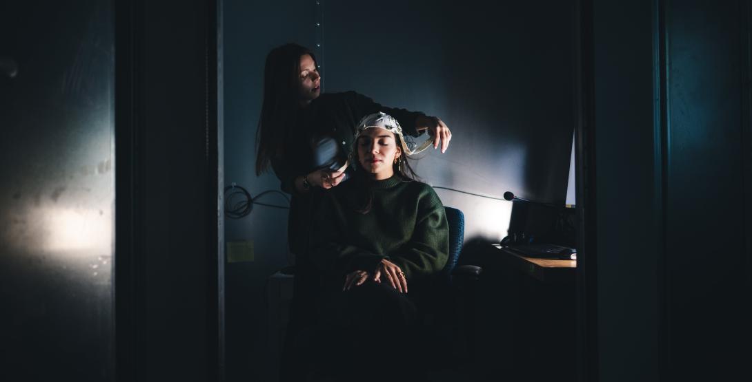 Haley Bennett puts a cap on another student to test pulses in the brain.